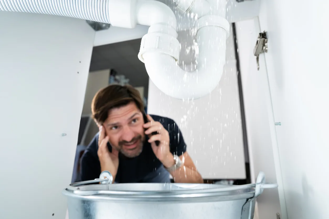 Phend Plumbing technician inspecting under-sink plumbing in a Mesa Arizona home