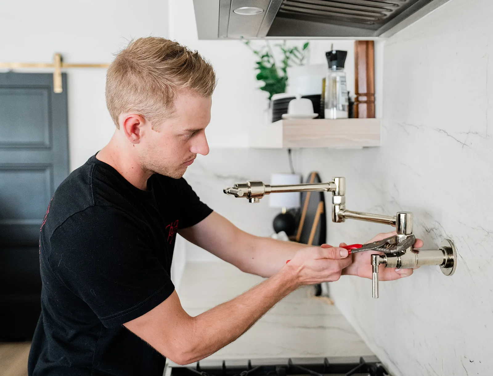 Phend Plumbing technician installing a pot filler faucet in an East Valley kitchen