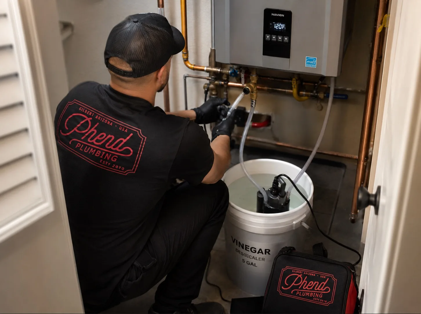 Phend Plumbing technician running a vinegar descale through a tankless water heater